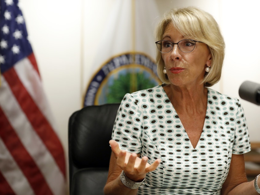 caption: Education Secretary Betsy DeVos speaks with the media after a series of listening sessions about campus sexual violence in July 2017.