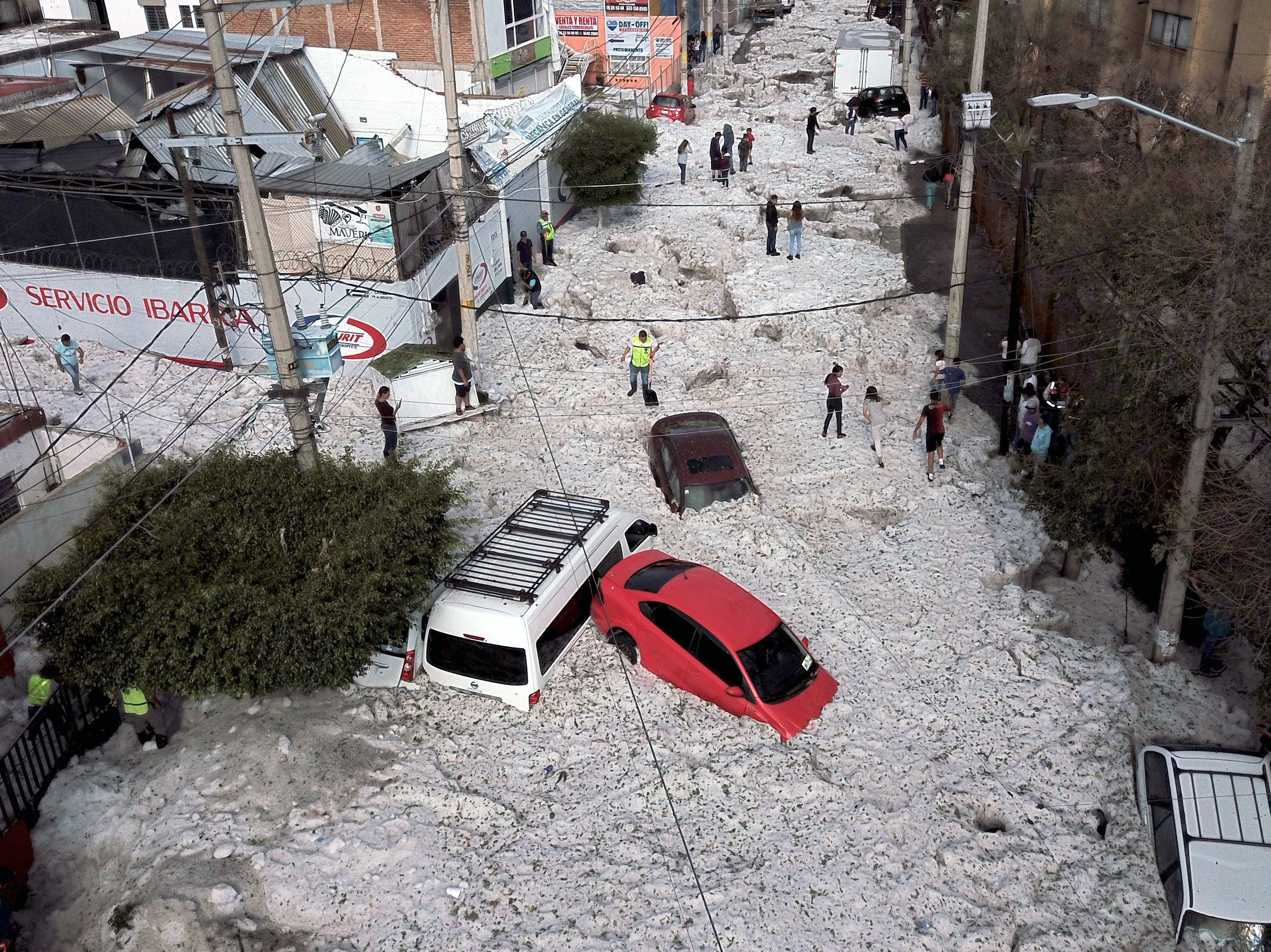 caption: Vehicles were buried in hail on Sunday in eastern Guadalajara in Mexico's Jalisco state. The accumulation of hail buried vehicles and damaged homes.