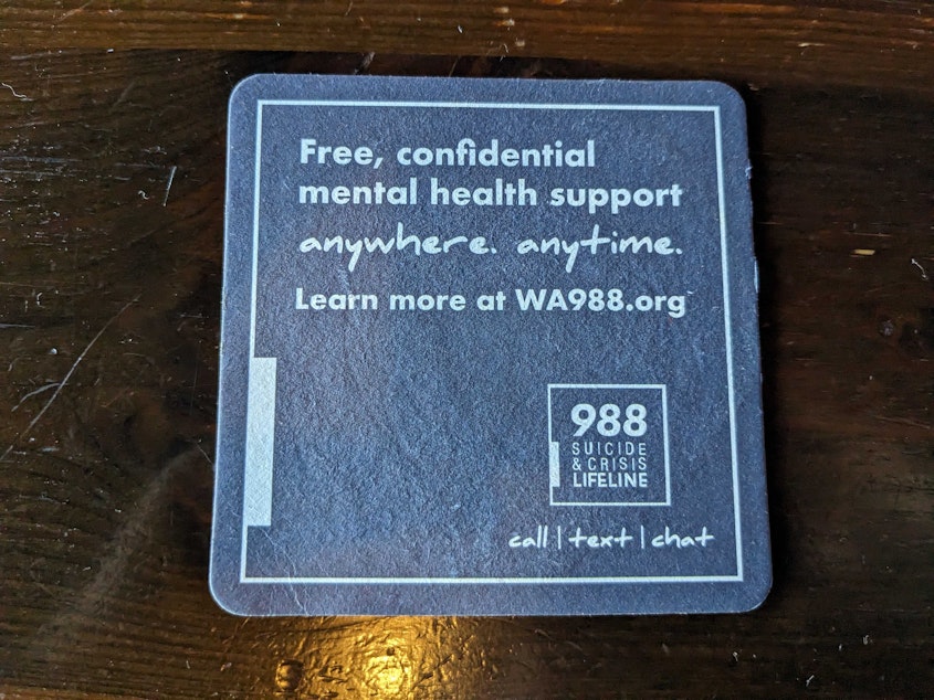caption: A coaster at a pub in Seattle advertises the 988 hotline in August 2024.