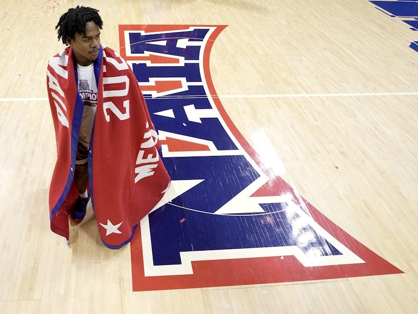 caption: Freed-Hardeman guard Quan Lax wears the championship banner after the NAIA men's national championship college basketball game against Langston, Tuesday, March 26, 2024, in Kansas City, Mo.
