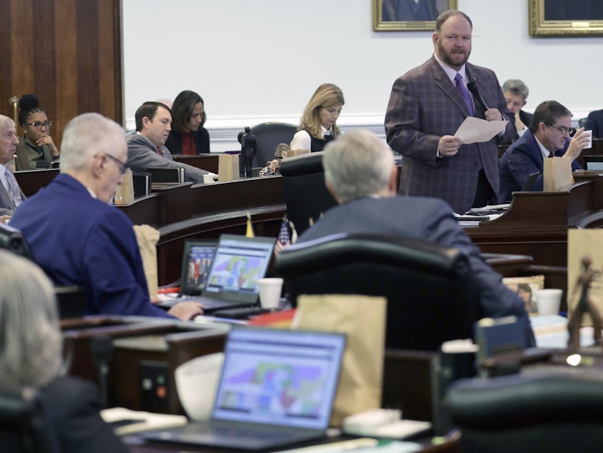 caption: While other senators look at the map on their computers, Republican Sen. Ralph Hise, top right, one of the sponsors of a congressional redistricting bill, speaks as the North Carolina Senate debates the bill Tuesday in Raleigh, N.C.