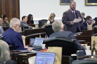 caption: While other senators look at the map on their computers, Republican Sen. Ralph Hise, top right, one of the sponsors of a congressional redistricting bill, speaks as the North Carolina Senate debates the bill Tuesday in Raleigh, N.C.