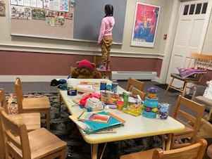 caption: A young girl is shown staying at a shelter on Martha's Vineyard, Mass., after she and dozens of other migrants arrived by plane unannounced Wednesday.