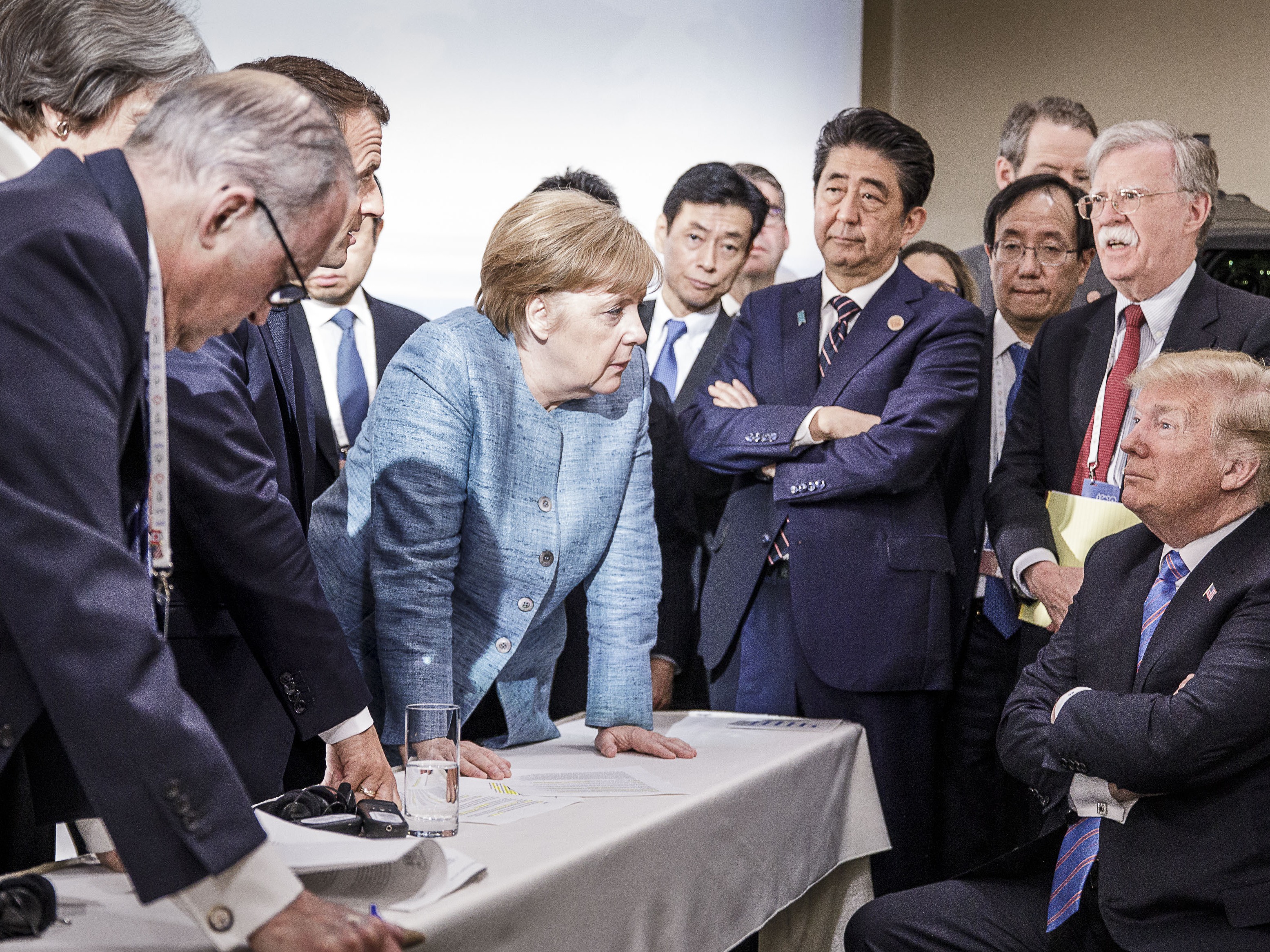caption: In this photo provided by the German Government Press Office (BPA), German Chancellor Angela Merkel deliberates with President Trump on June 9, 2018, at the G7 summit in Charlevoix, Canada.
