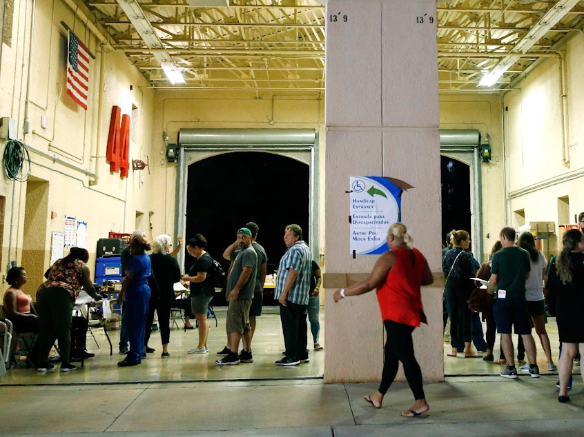 caption: South Florida voters wait in line to cast their ballots late in the day at a busy polling center in Miami on Nov. 6, 2018.