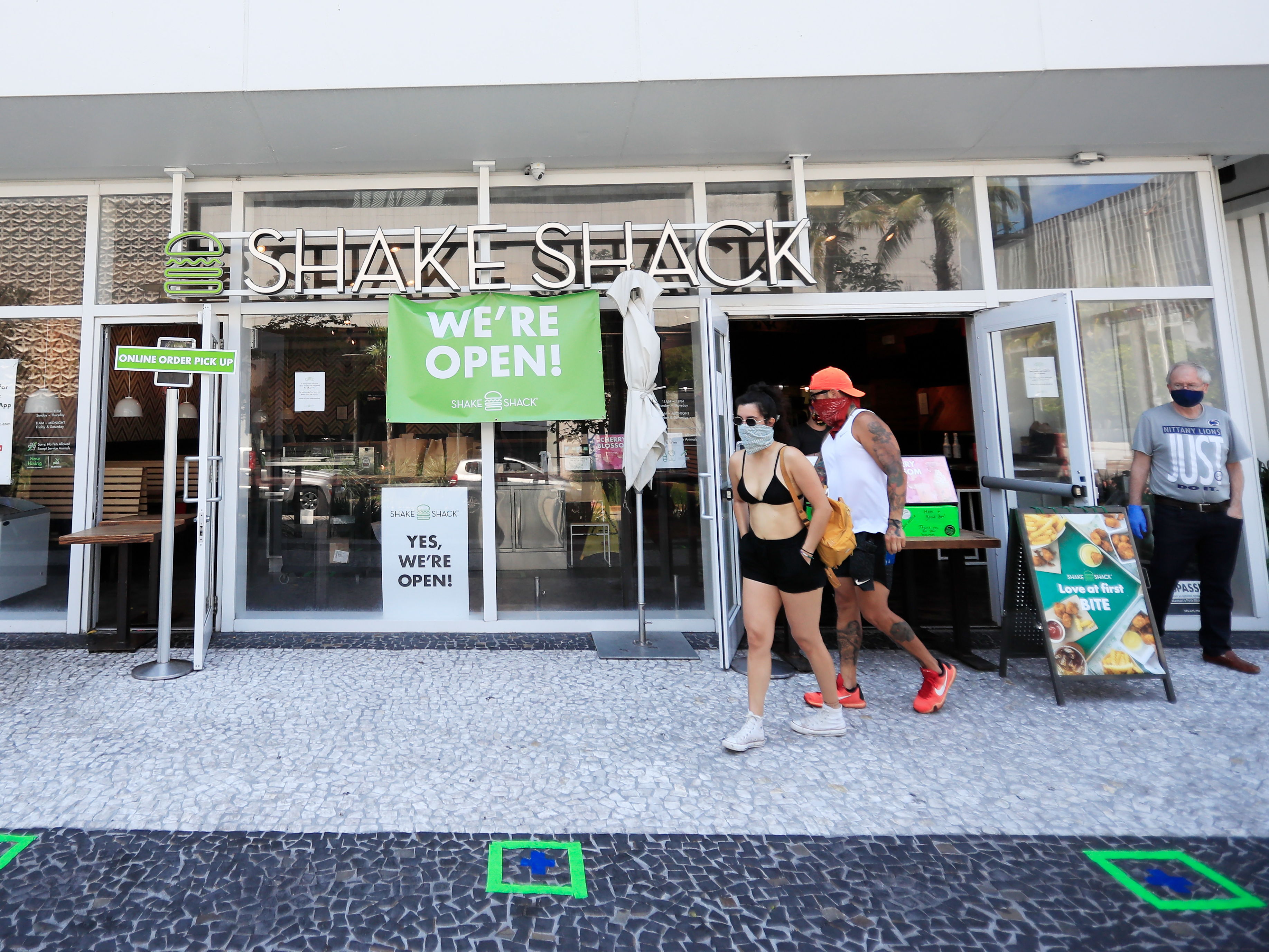 caption: Shake Shack is returning a $10 million loan to the Small Business Administration, saying the money should go to restaurants that need it more. Here, customers wait for to-go orders outside a Shake Shack in South Beach in Miami Beach, Fla., over the weekend.