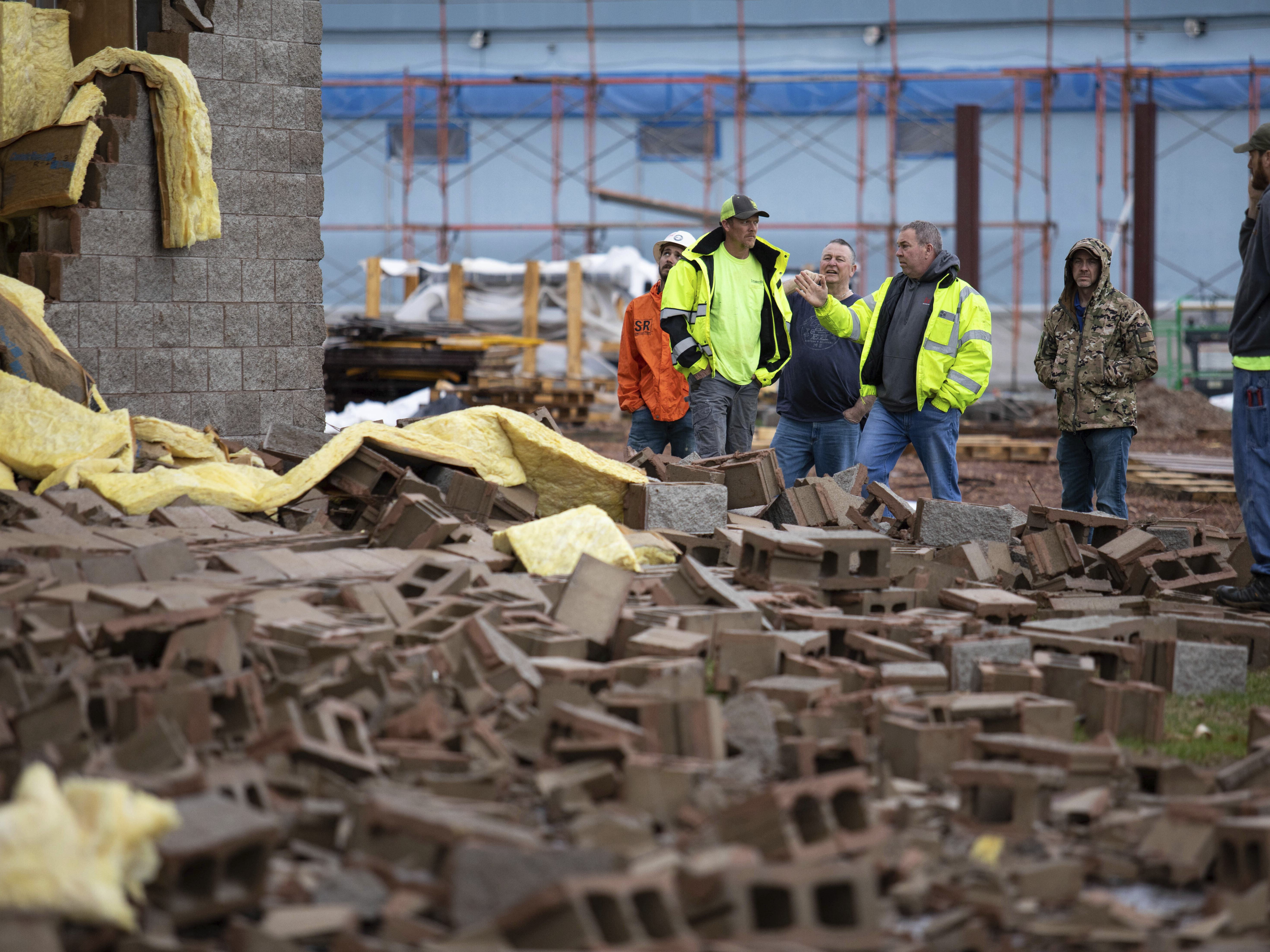 caption: Utility workers and city crews survey and help clear debris at Thornton Furniture in Bowling Green, Ky., after a tornado warning was issued on Saturday for Warren and surrounding counties.