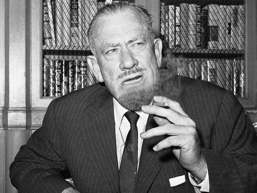 caption: John Steinbeck talks to media in the office of his publisher in New York on Oct. 25, 1962.