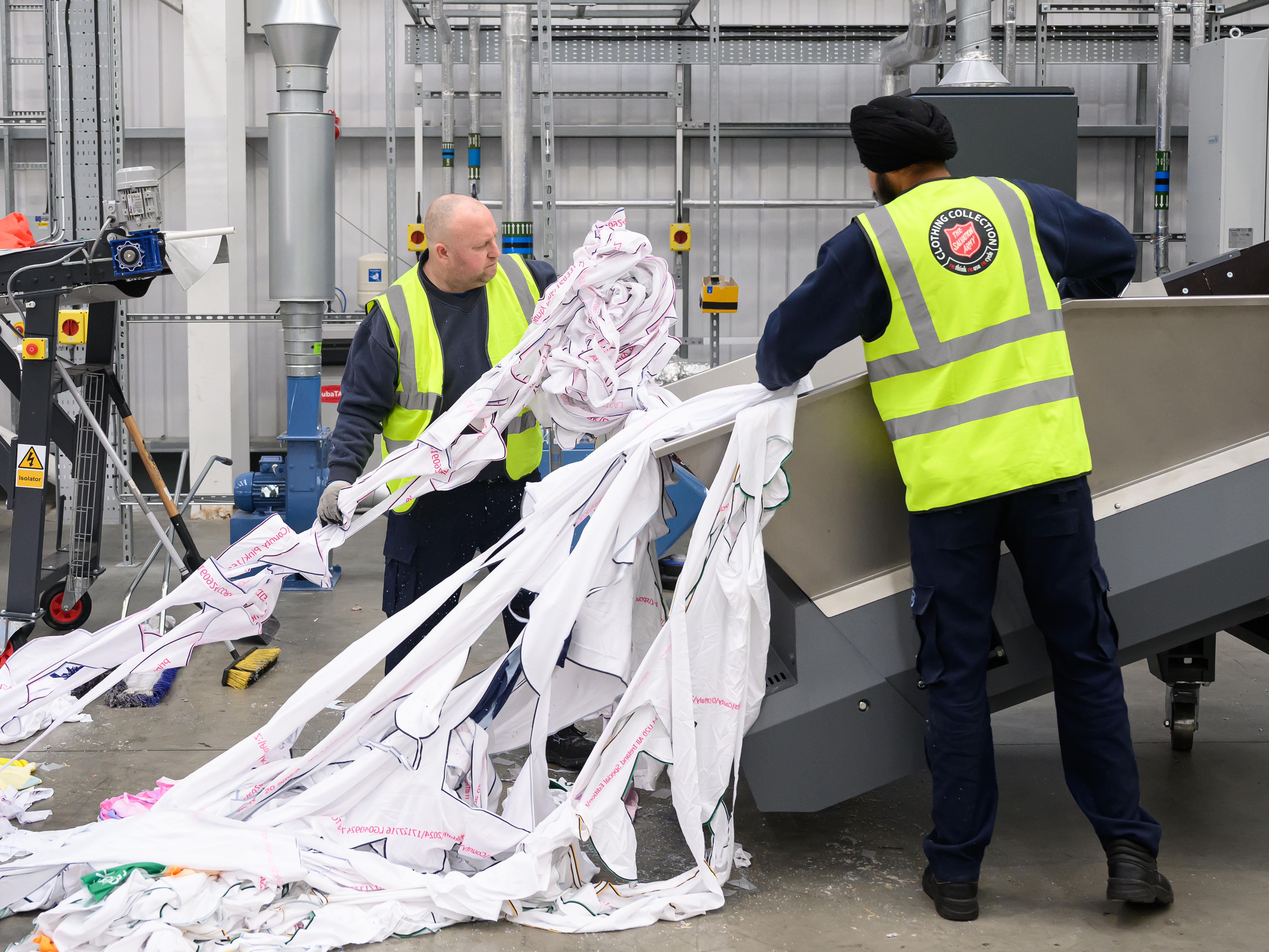 caption: Workers load unwanted polyester textiles into the Project Re:Claim system, the first commercial-scale polyester recycling plant of its kind, last year in Kettering, England.