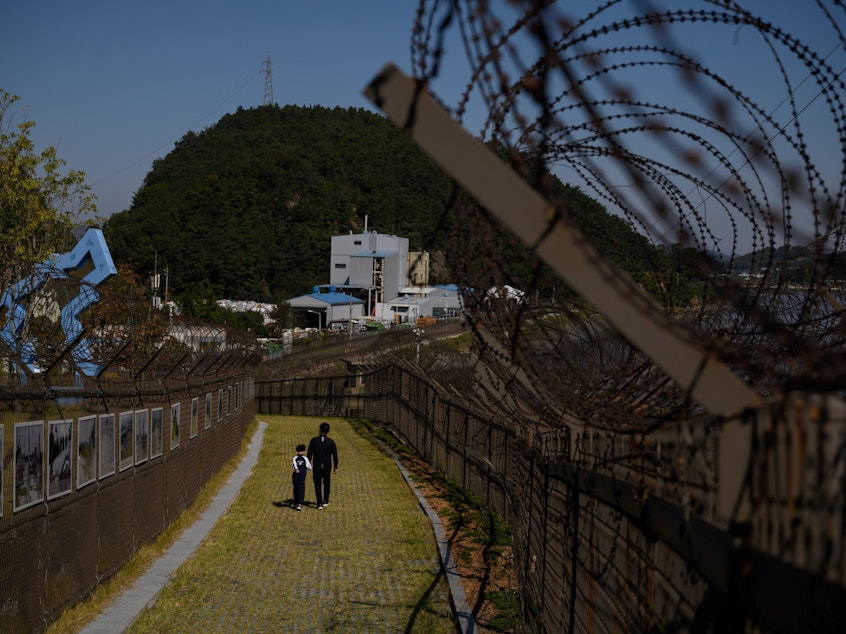 caption: A North Korean man defected to South Korea by hopping a fence along the Demilitarized Zone separating the two countries.