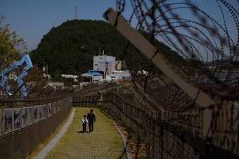 caption: A North Korean man defected to South Korea by hopping a fence along the Demilitarized Zone separating the two countries.