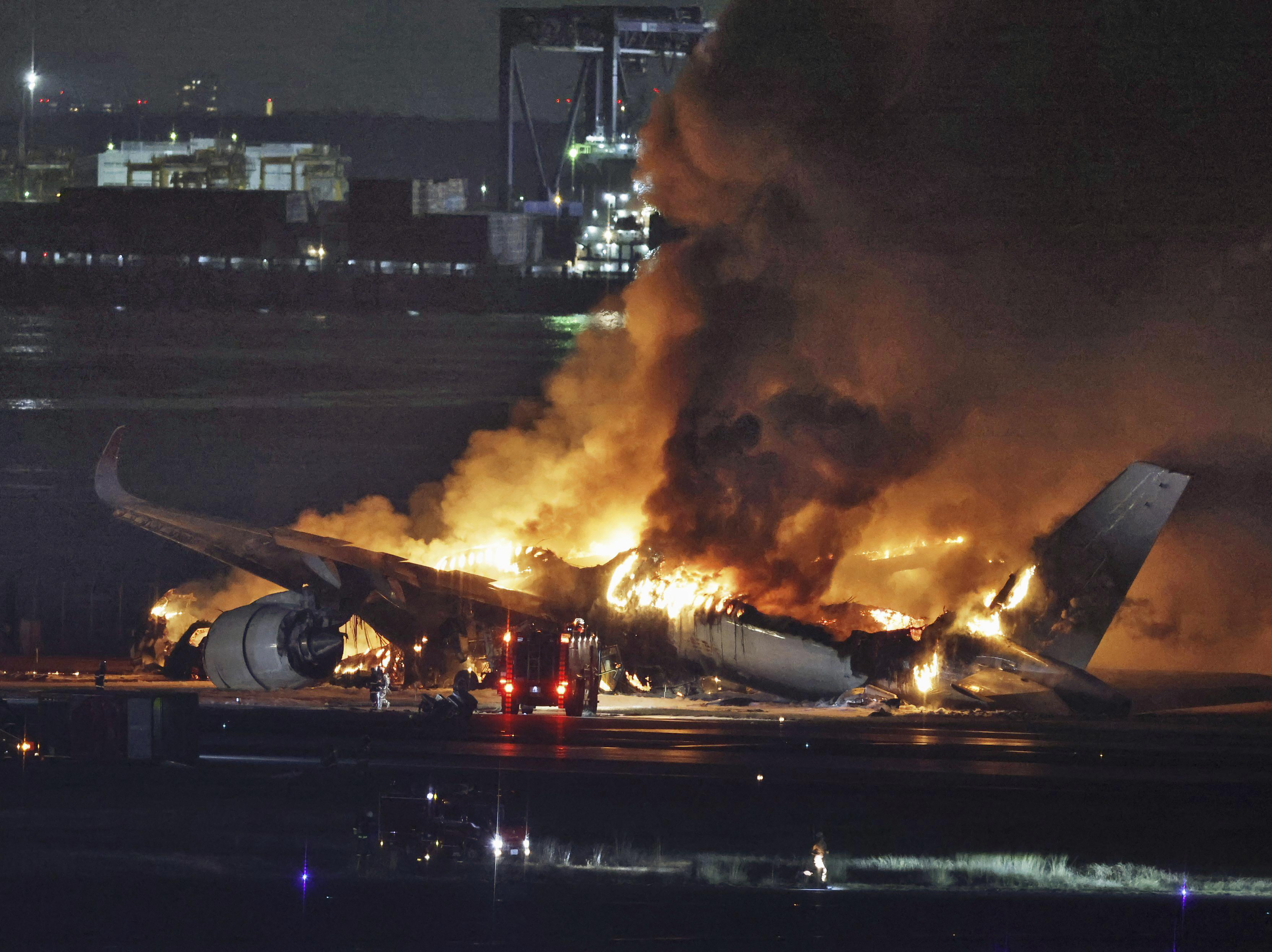 caption: A Japan Airlines plane is on fire on the runway of Haneda airport on Tuesday in Tokyo.