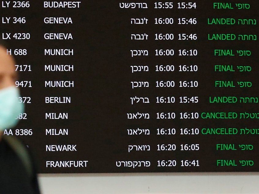 caption: A flight information board displays canceled incoming flights from Italy at Ben Gurion International Airport, near Tel Aviv, Israel, last month. Airlines are slashing hundreds of flights amid fear of the spreading coronavirus.