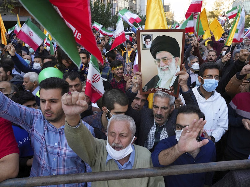 caption: Demonstrators chant slogans Friday as one of them holds up a poster of Iranian Supreme Leader Ayatollah Ali Khamenei during a demonstration in front of the former U.S. Embassy in Tehran, Iran.