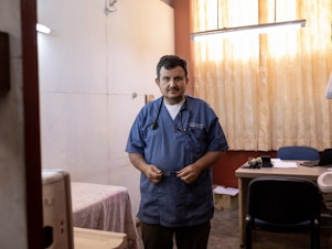 caption: Raymond Portelli, priest and doctor, in his office in the San Martin de Porres church in Iquitos, Peru. In the early days of the pandemic, he says he wasn't too worried about this new coronavirus. But his early optimism would quickly evaporate.