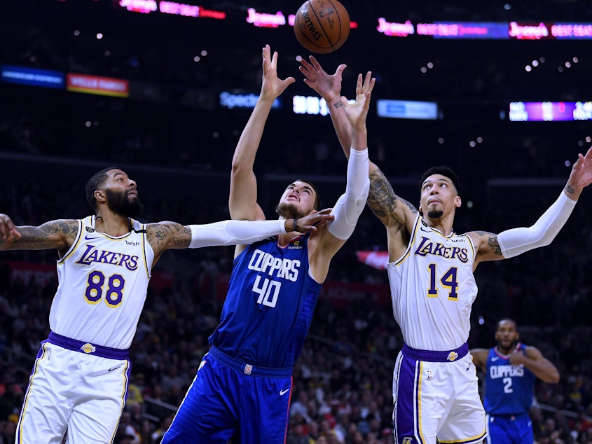 caption: Players from the Los Angeles Clippers and Los Angeles Lakers, shown here during a game in March, will face each other on Thursday evening as the NBA season restarts.