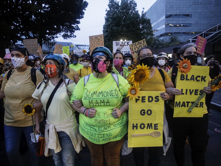 caption: Members of the "Wall of Moms" march during a Black Lives Matter protest at the Mark O. Hatfield United States Courthouse last week in Portland, Ore.