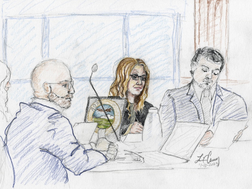 caption: A sketch depicts Madison County prosecutor Rob Wood (from left), Lori Vallow Daybell and defense attorney Jim Archibald during opening statements of Vallow Daybell's murder trial in Boise, Idaho, on Monday.