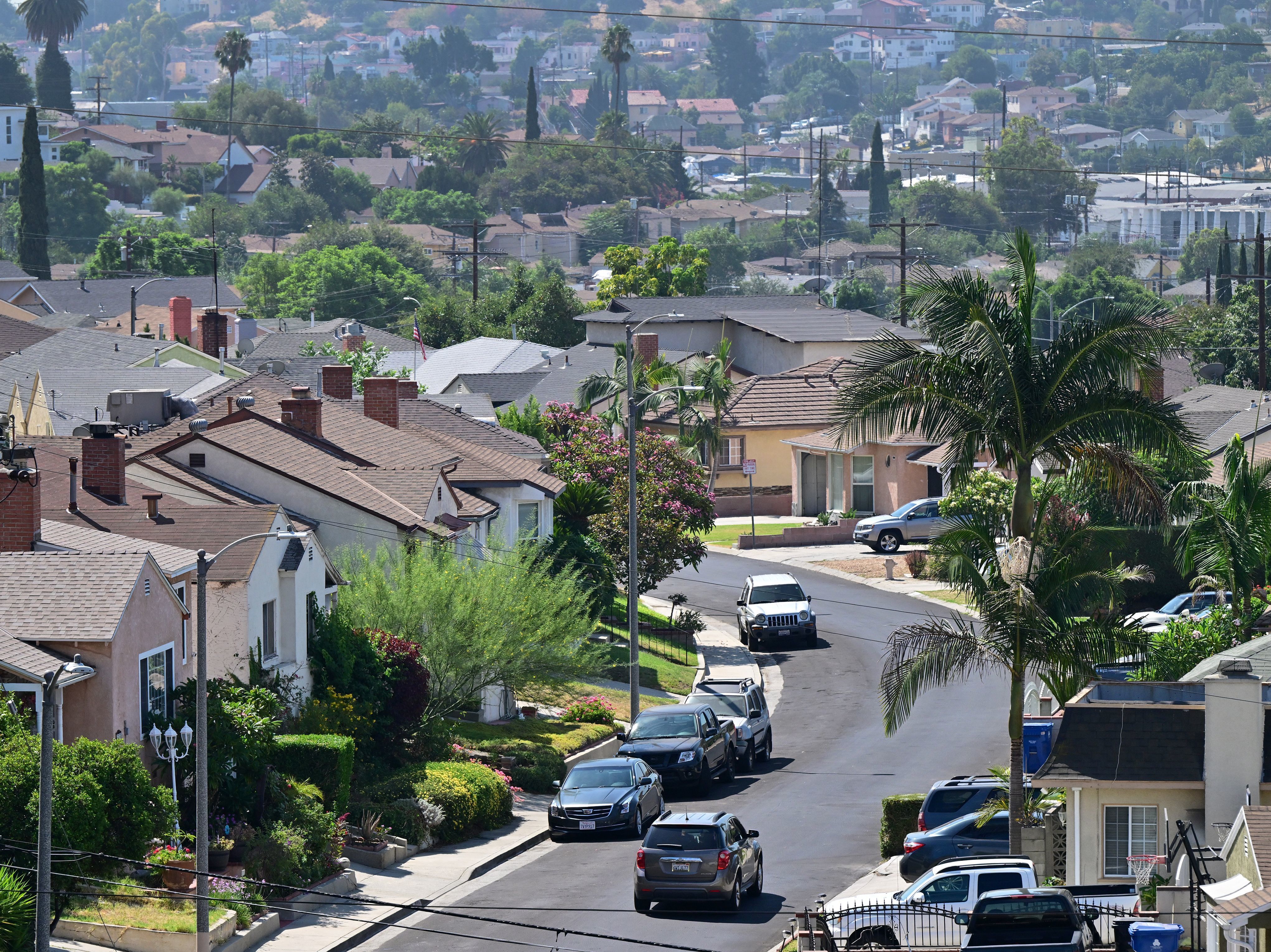 caption: A vehicle drives through a residential neighborhood in Los Angeles.