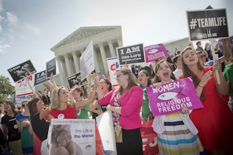 caption: In this 2014 photo, demonstrators react to hearing the Supreme Court's decision on the Hobby Lobby birth control case outside the Supreme Court in Washington. A judge in California has blocked implementation of a Trump administration policy that would let more employers decline to offer birth control coverage on religious or moral grounds.
