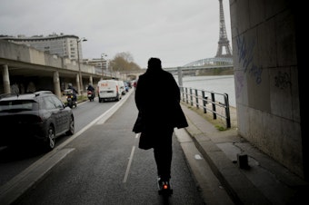 caption: A man rides a scooter in Paris, on March 31. The city has now banned rental electric scooters.