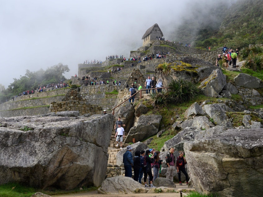 caption: Tourists visit the Machu Picchu complex, the Inca fortress in the southeastern Andes of Peru in April. The government hopes a new airport will attract more tourists to the ancient site. That draws opposition from conservationists.