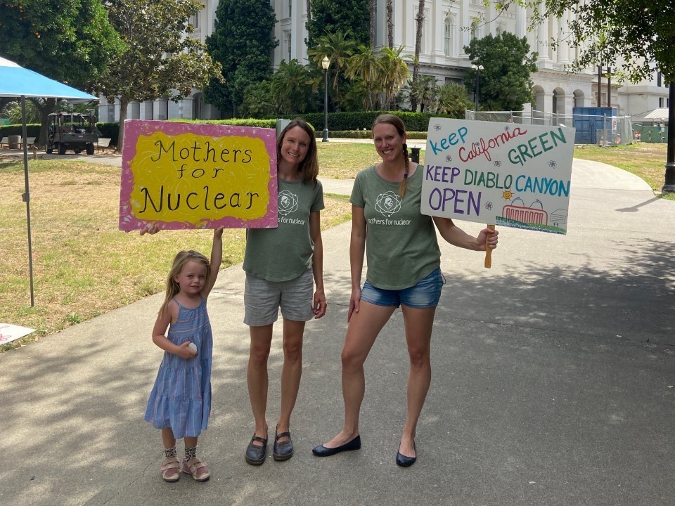 caption: Kristin Zaitz, left, and Heather Hoff of Mothers for Nuclear and Kristin's daughter Sasha make their views clear in front of California's state house.
