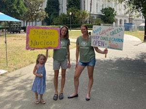 caption: Kristin Zaitz, left, and Heather Hoff of Mothers for Nuclear and Kristin's daughter Sasha make their views clear in front of California's state house.