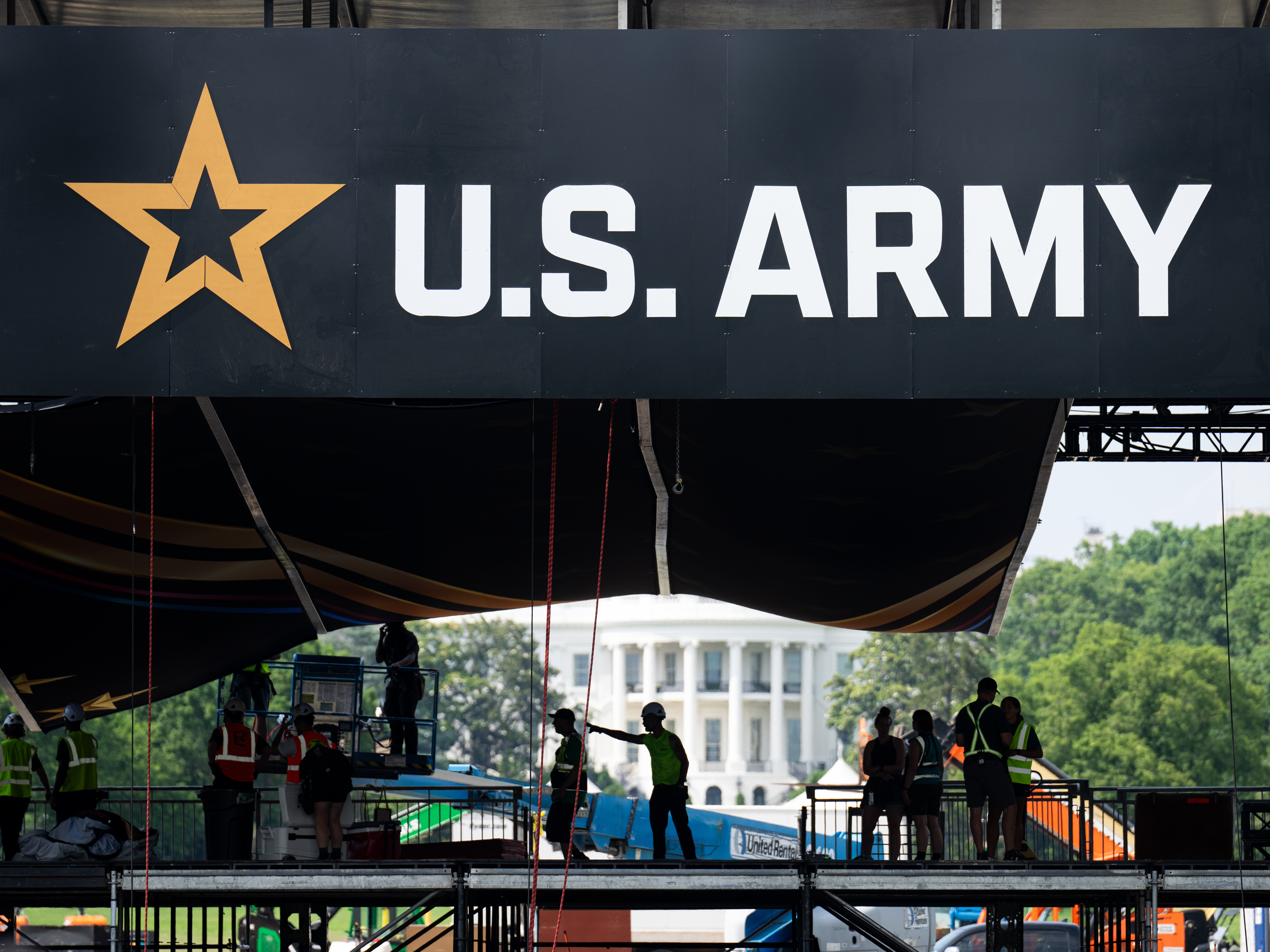 caption: Workers set up the reviewing stand in front of the White House on June 10 for the U.S. Army's 250th anniversary parade.