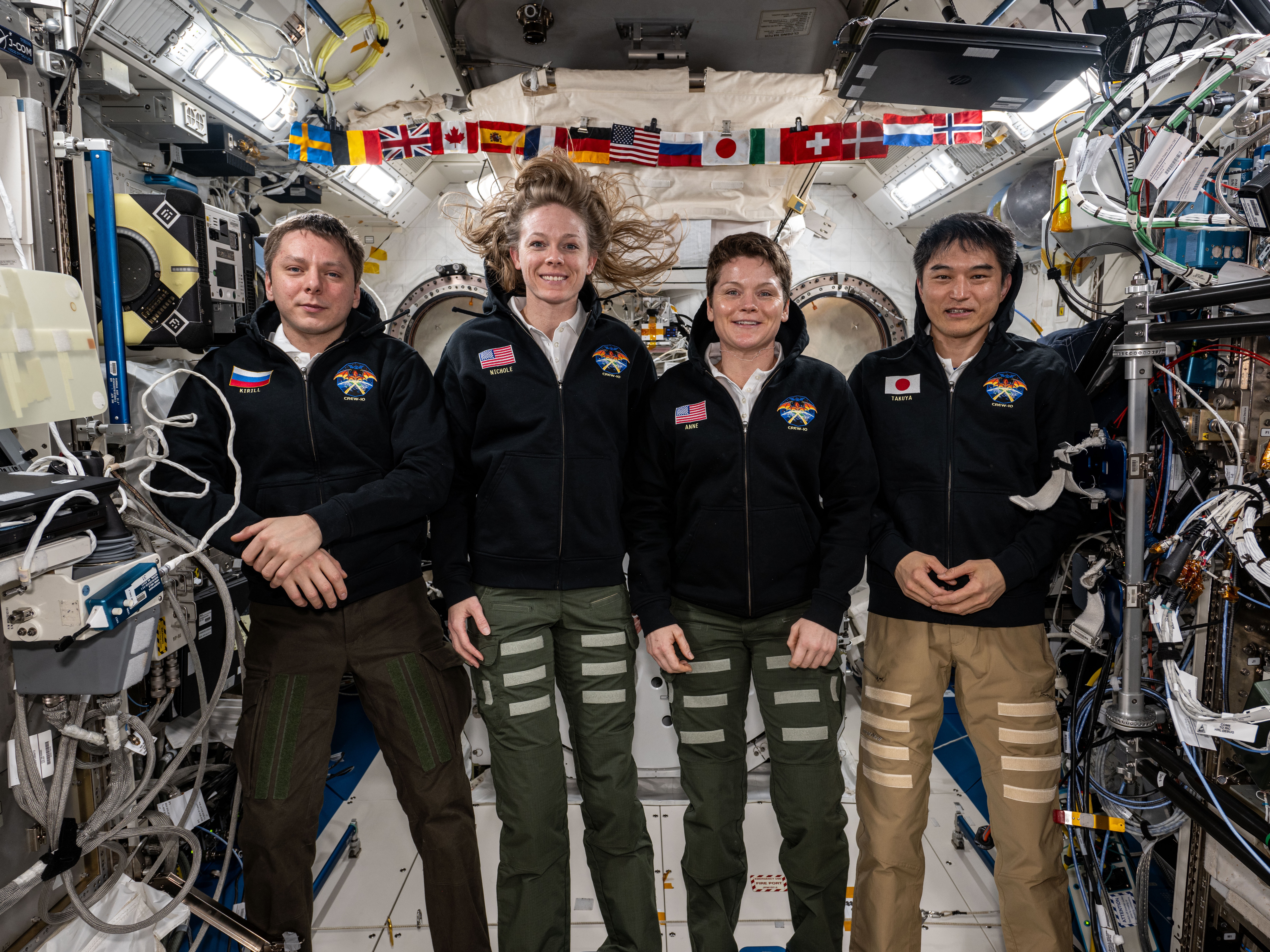 caption: From left, NASA's SpaceX Crew-10 members Kirill Peskov of Roscosmos, NASA astronauts Nichole Ayers and Anne McClain, and JAXA (Japan Aerospace Exploration Agency) astronaut Takuya Onishi pose for a group portrait inside the International Space Station's Kibo laboratory module on July 19, 2025.