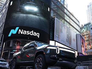 caption: A Rivian electric truck is displayed near the Nasdaq MarketSite building in Times Square on November 10, 2021 in New York City. Rivian, an electric truck maker backed by Amazon and Ford, made its debut at Nasdaq in one of the biggest IPOs in U.S. history.