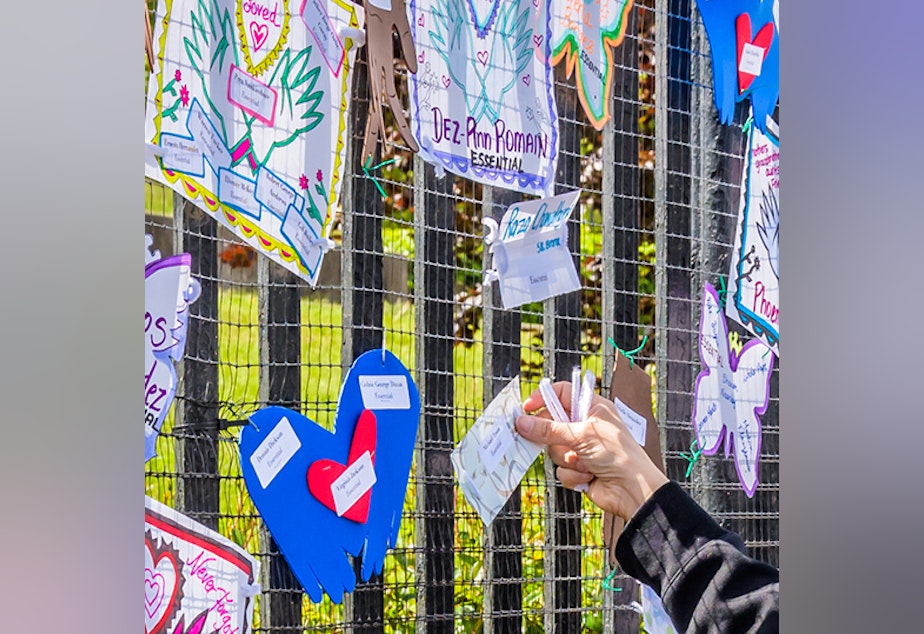 caption: A volunteer artist sets up a memorial May 20 in Brooklyn. Artists and volunteer organizers across New York City put up memorials throughout the five boroughs to honor those who died of COVID-19.