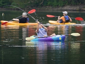 caption: A fisherman in a kayak makes a cast on Lake Arthur at Moraine State Park in Portersville, Pa. Sales of camping, outdoor and recreational equipment have been surging.