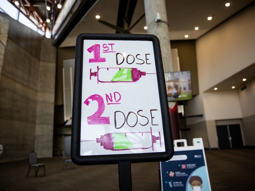 caption: Signs direct people arriving to get COVID-19 vaccines at the Mountain America Expo Center in Sandy, Utah, on April 22.