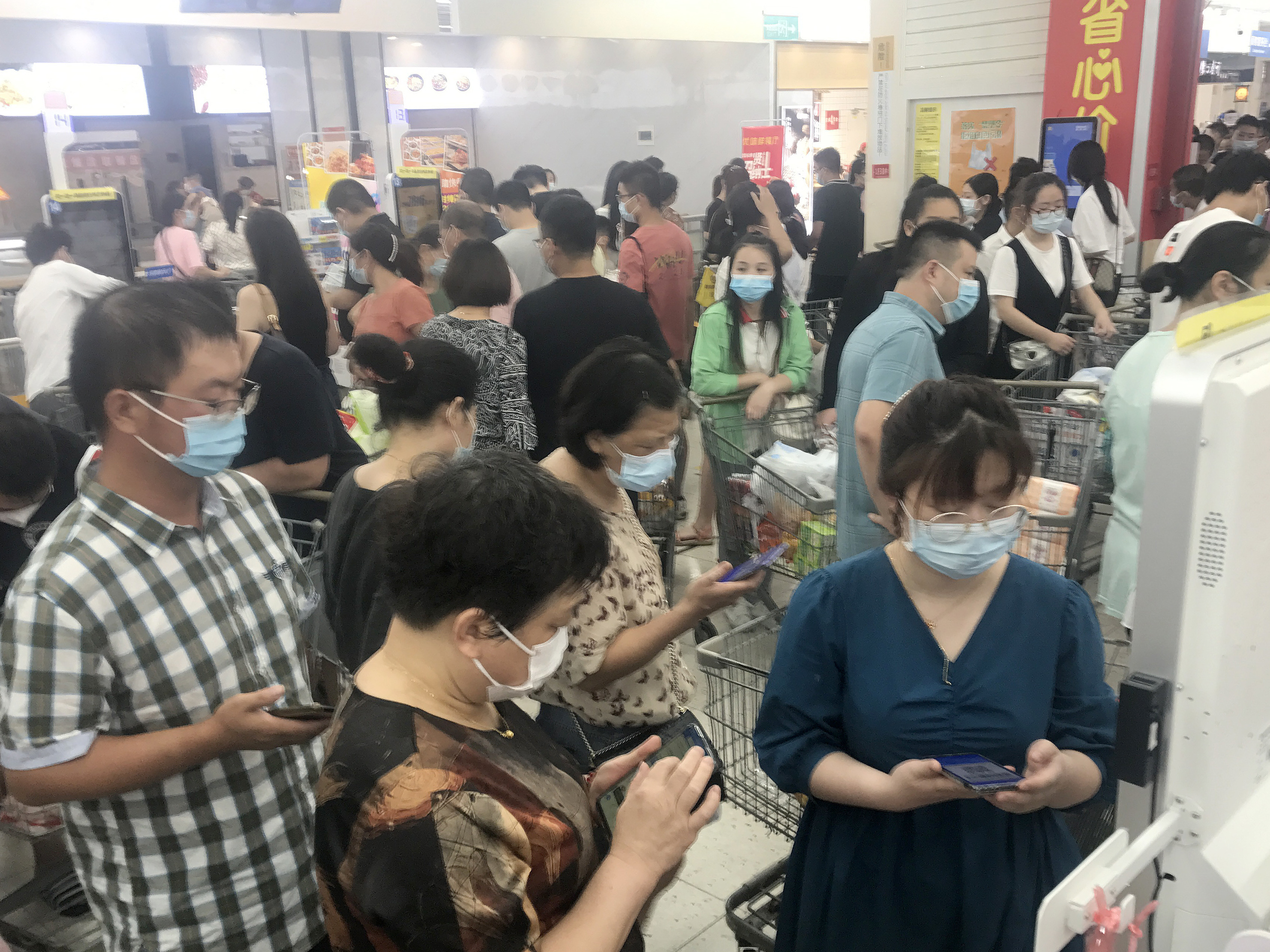 caption: Panic shopping in a supermarket in Wuhan, China, after several nearby residential blocks went into lockdown in the COVID-19 prevention on Monday.