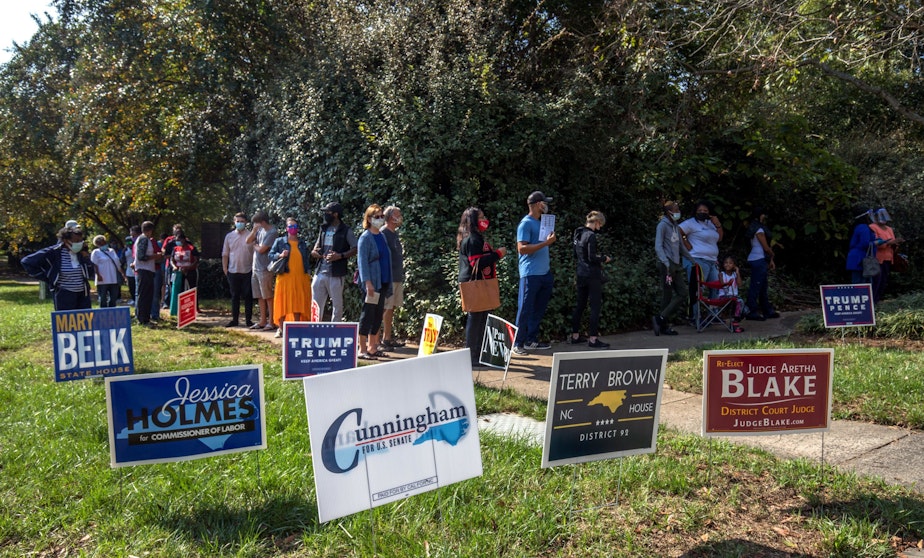 caption: Voters in Charlotte, North Carolina, wait in line to cast their ballots at the West Boulevard branch of the Mecklenburg County library on October 15, 2020, the first day of early voting. (Grant Baldwin/AFP via Getty Images)