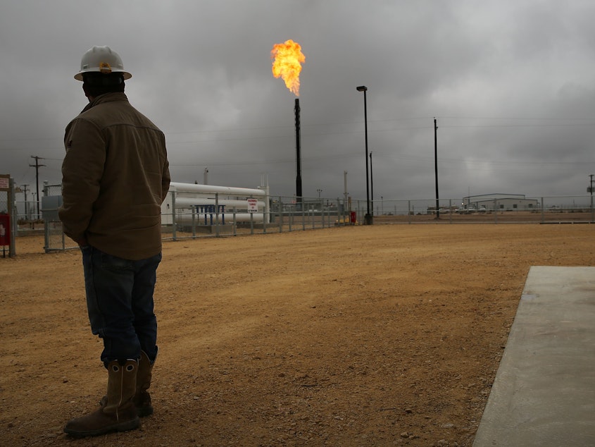 caption: Flared natural gas is burned off at Apache Corporations operations at the Deadwood natural gas plant in the Permian Basin on February 5, 2015 in Garden City, Texas.