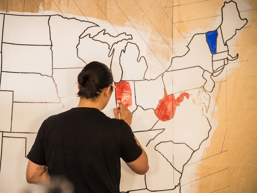 caption: An artist paints a mural, indicating which presidential candidates had won certain states on election night in 2016. Once again, NPR will rely on the Associated Press to provide election results and race calls.