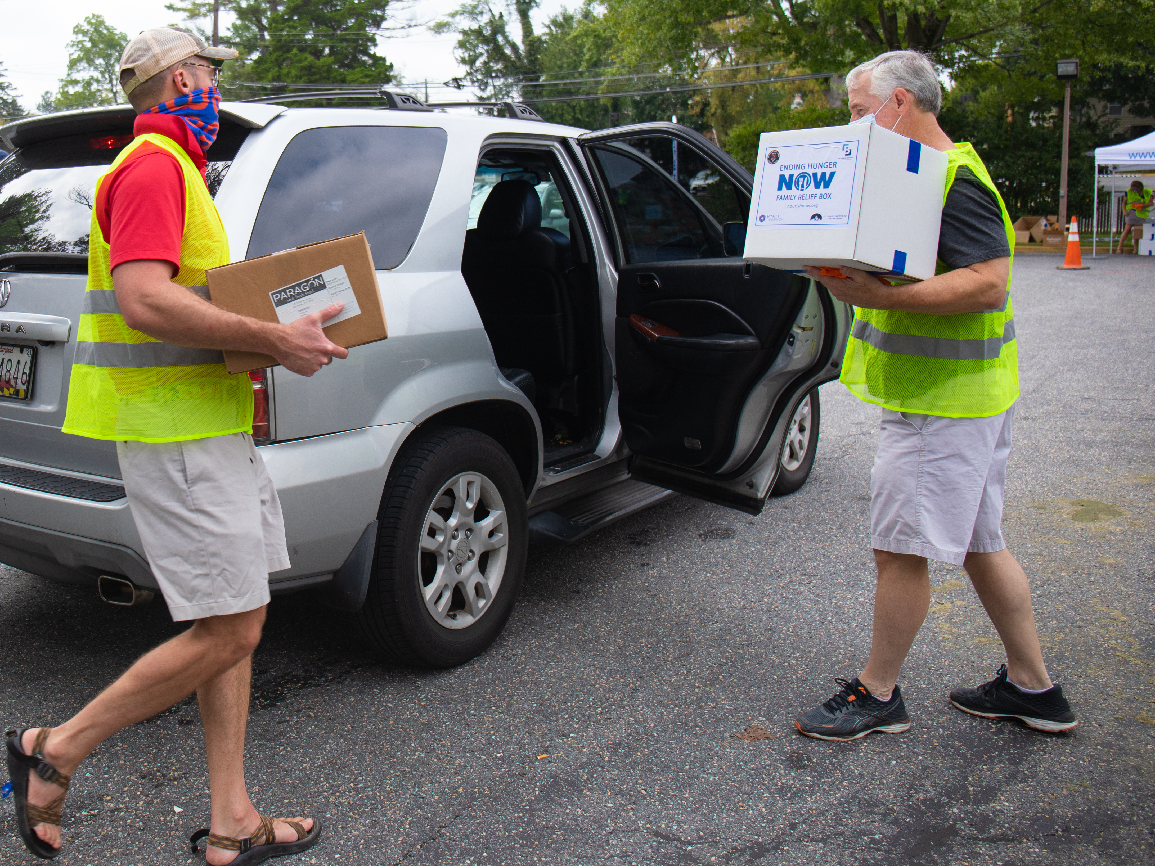 caption: Volunteers from St. John's Episcopal Church in Bethesda help hand out food to a local resident at an event earlier this month.