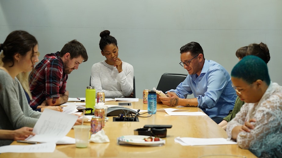 caption: Raymond Power, center right, and cast members at table read for "Give Me Shelter"