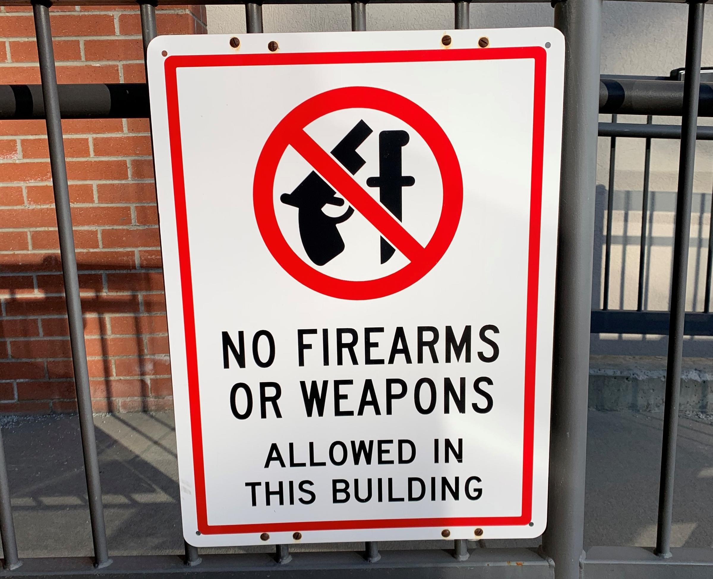 caption: A "No Firearms" sign outside of the Bonner County Courthouse in Sandpoint, where the case, Bonner County v. City of Sandpoint, is being heard.