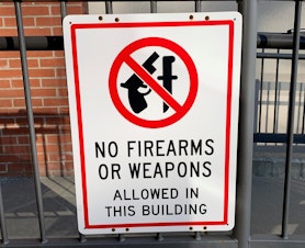 caption: A "No Firearms" sign outside of the Bonner County Courthouse in Sandpoint, where the case, Bonner County v. City of Sandpoint, is being heard.