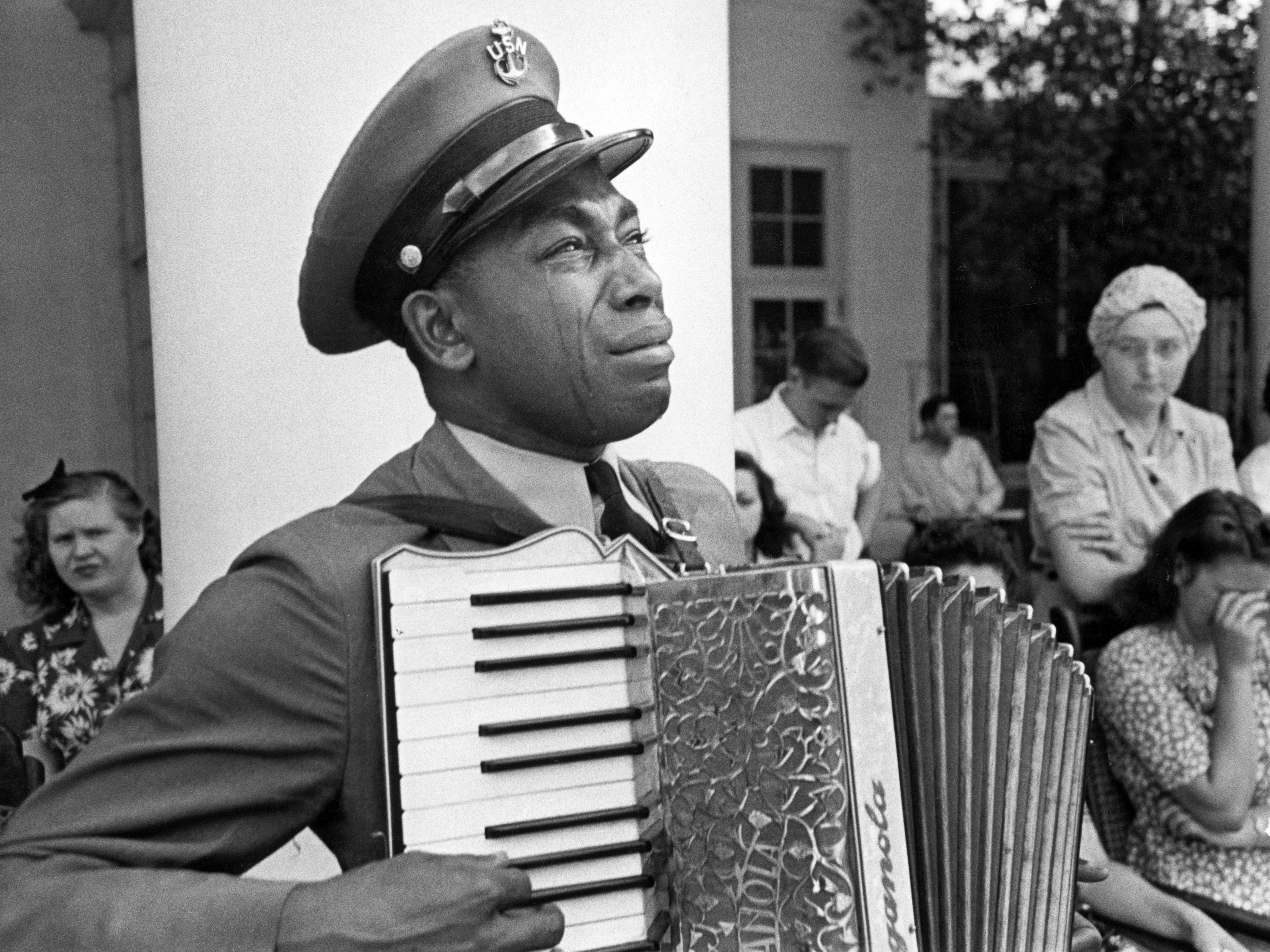 caption: U.S. Navy CPO Graham Jackson, with tears of grief, plays "Goin' Home," from Dvorak's 'New World' Symphony, as President Franklin D. Roosevelt's body is carried from Warm Springs, Ga., where he died.