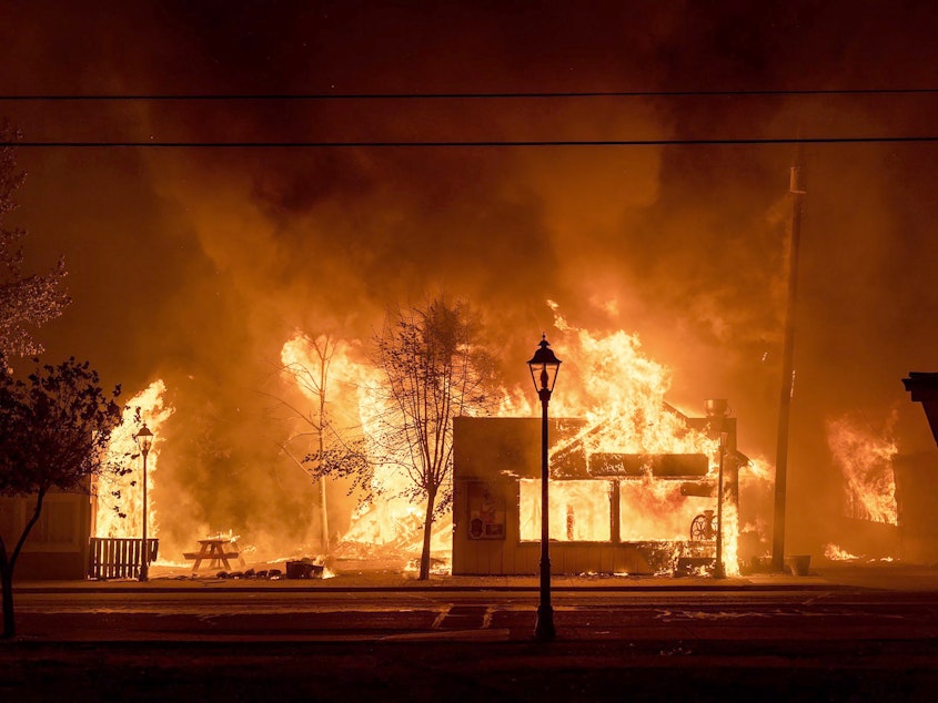 caption: Buildings are engulfed in flames as a wildfire ravages Talent, Ore., on Sept. 8, 2020. Unfounded rumors that left-wing activists were behind the fires went viral on social media, thanks to amplification by conspiracy theorists and the platforms' own design.
