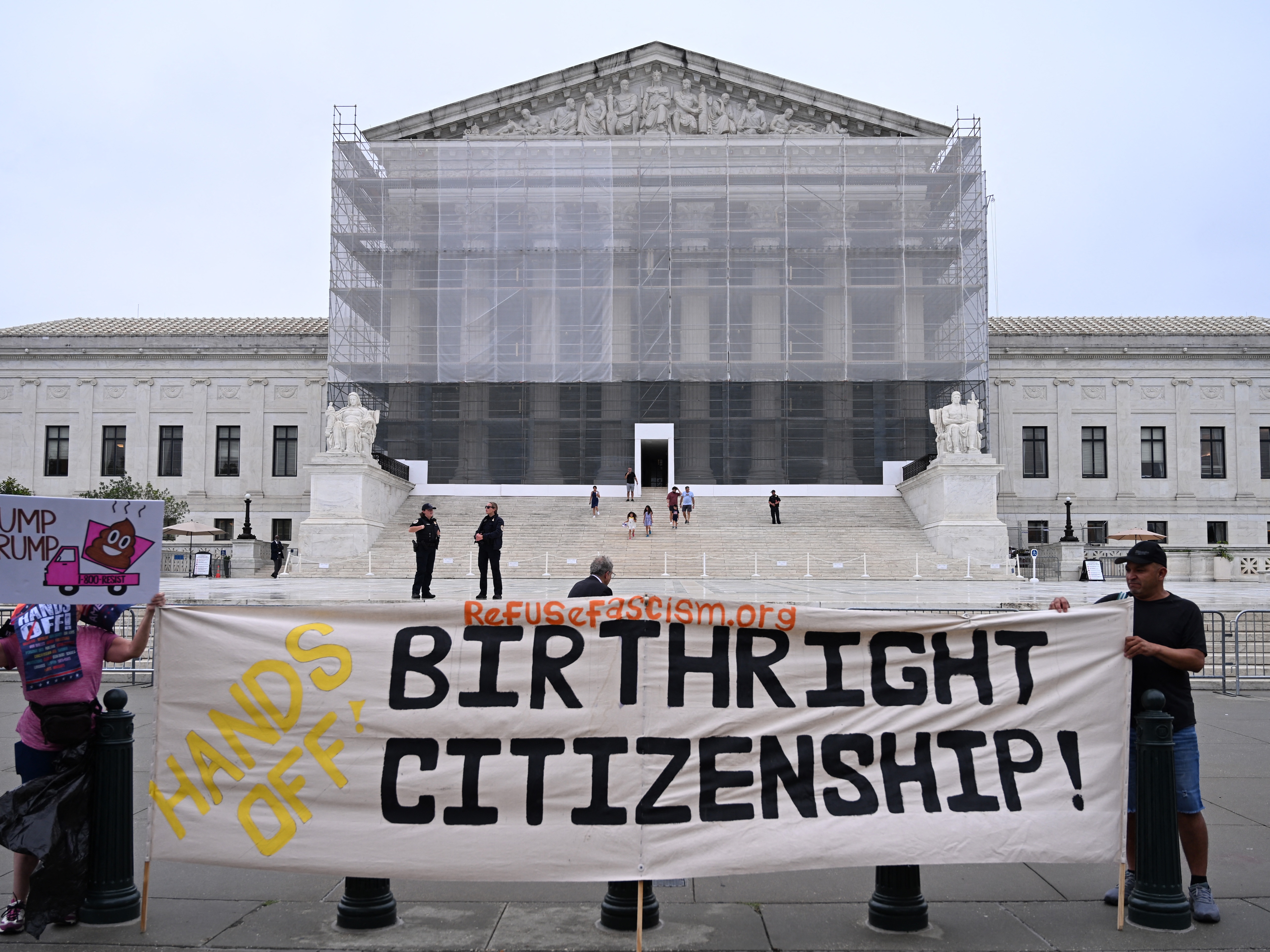 caption: Demonstrators hold up anti-Trump signs outside the U.S. Supreme Court in Washington, D.C., on June 27, 2025.