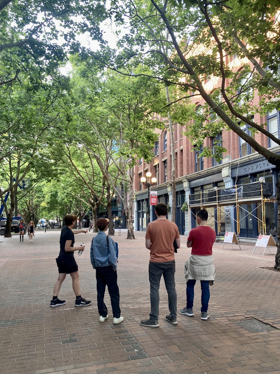 caption: Beneath the Streets guide Terrilyn Johnson shows tourgoers the spot in Pioneer Square where Seattle's first Pride parade began.