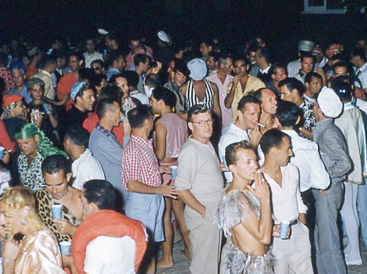 caption: People attend a party in Cherry Grove section of Fire Island in New York during the 1960s.
