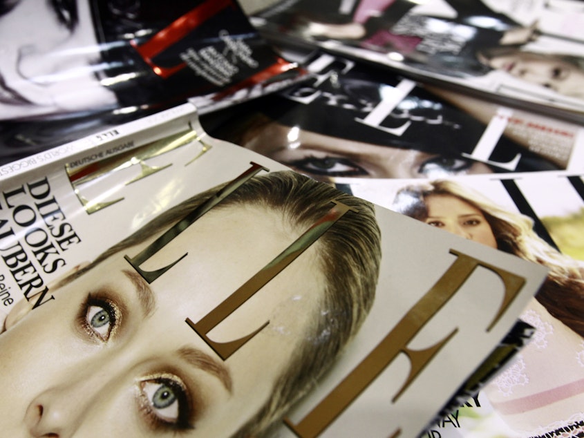 caption: A file picture taken in January 2011 in Paris shows covers of some of the 42 foreign editions of the French fashion magazine "Elle", owned by French media conglomerate Lagardere.