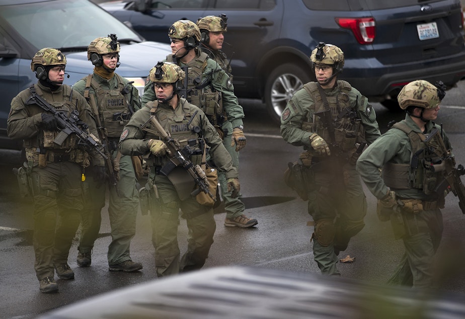 caption: Police officers walk through a parking lot on Friday, Feb. 16, 2018, after clearing Highline College due to reports of gun shots in Des Moines. Tap or click on the first image to see more.