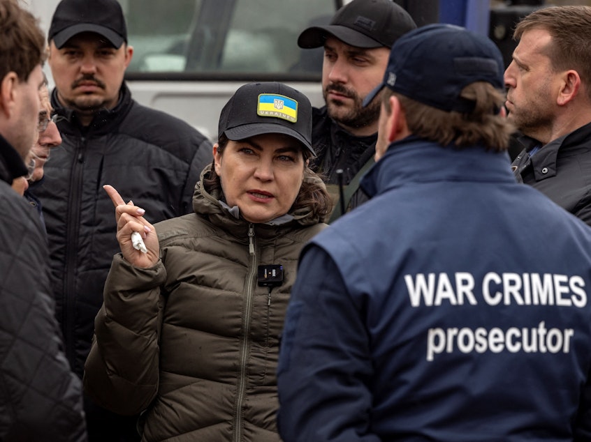 caption: Ukraine's Prosecutor General Iryna Venediktova visits a mass grave in Bucha, on the outskirts of Kyiv, on April 13, 2022. The International Criminal Court's chief prosecutor to Bucha visited as the front in Russia's invasion shifted eastward and new allegations of crimes inflicted on locals emerged.